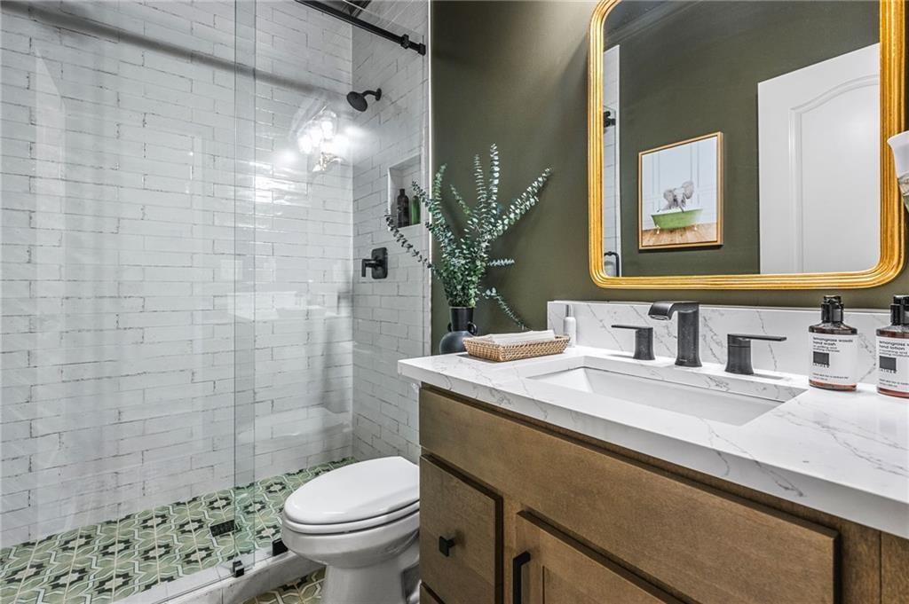 4526 Meadowland Way Flowery Branch, GA 30542 - Photo 22 of 64 a bathroom with a sink a toilet and shower