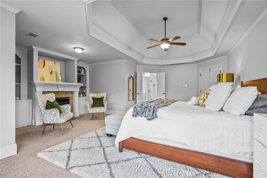 4526 Meadowland Way Flowery Branch, GA 30542 - Photo 26 of 64 a bedroom with a bed ceiling fan and a fireplace