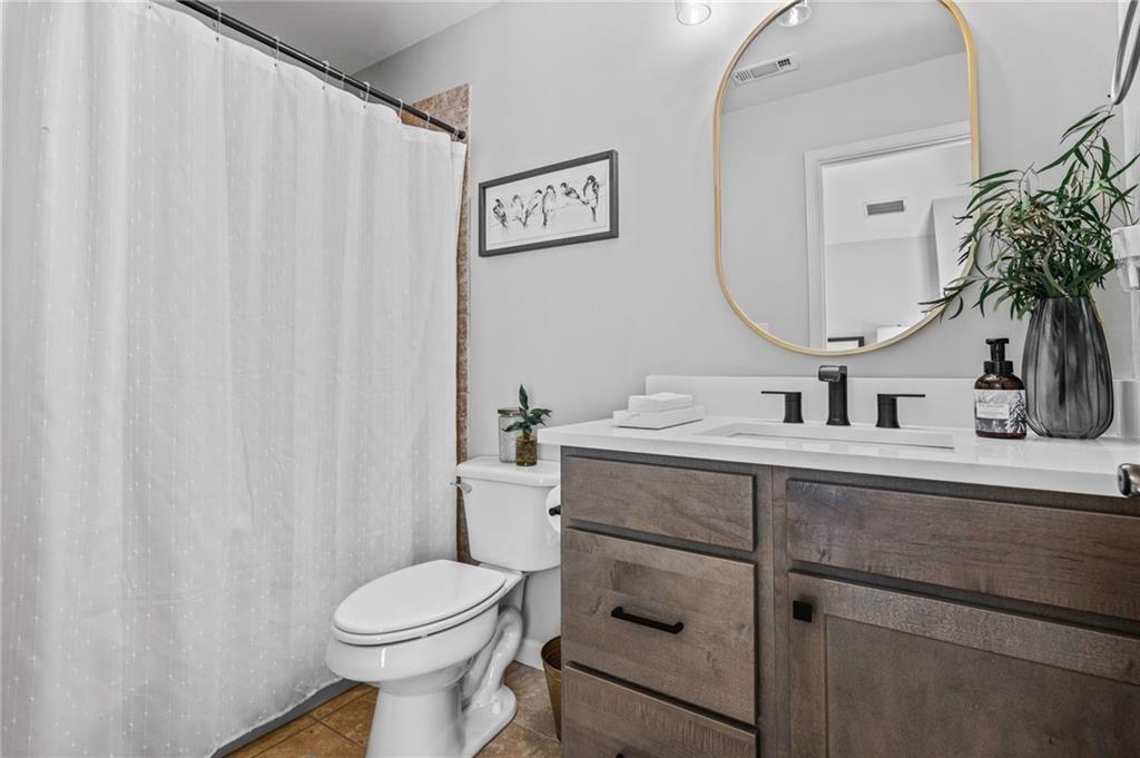 4526 Meadowland Way Flowery Branch, GA 30542 - Photo 34 of 64 a bathroom with a toilet sink and mirror