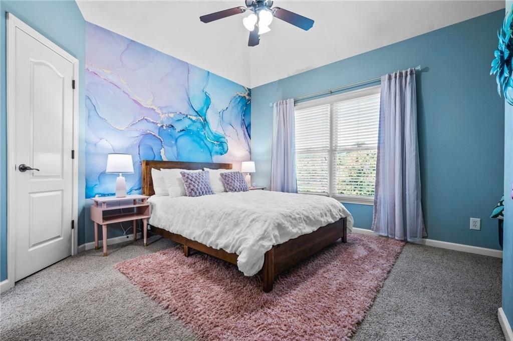 4526 Meadowland Way Flowery Branch, GA 30542 - Photo 35 of 64 a spacious bedroom with a bed and a chandelier