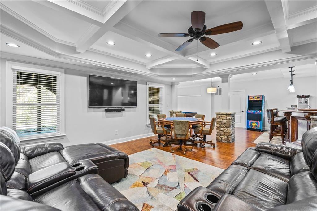 4526 Meadowland Way Flowery Branch, GA 30542 - Photo 38 of 64 a living room with furniture and a flat screen tv with kitchen view