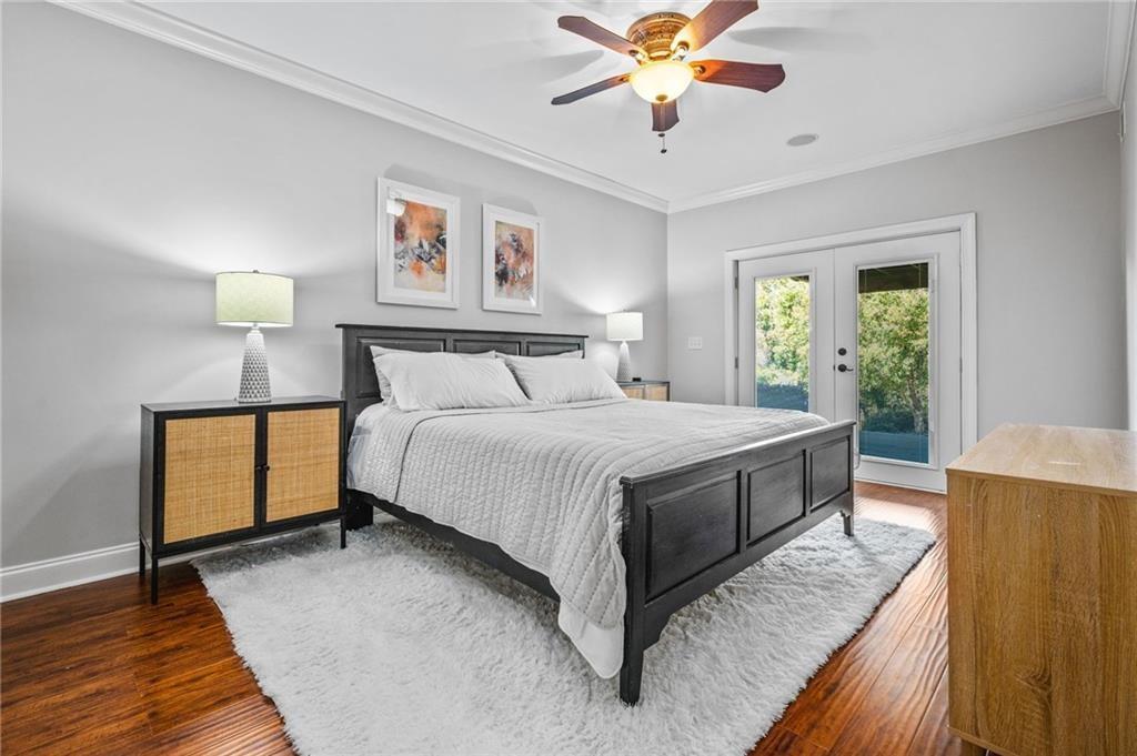 4526 Meadowland Way Flowery Branch, GA 30542 - Photo 46 of 64 a bedroom with a bed and a chandelier