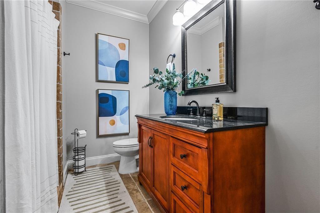 4526 Meadowland Way Flowery Branch, GA 30542 - Photo 47 of 64 a bathroom with a toilet a sink and mirror