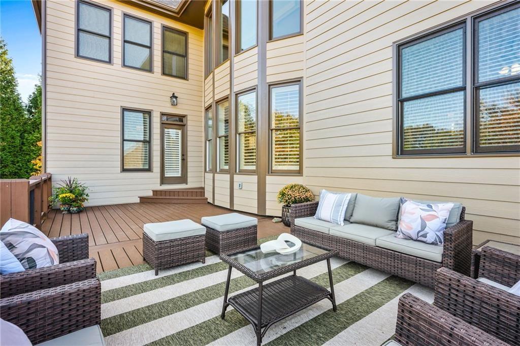 4526 Meadowland Way Flowery Branch, GA 30542 - Photo 50 of 64 a view of a patio with couches chairs and wooden floor