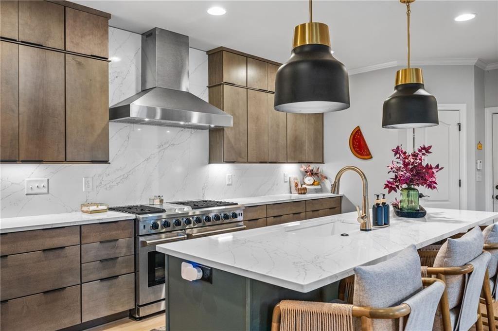 4526 Meadowland Way Flowery Branch, GA 30542 - Photo 10 of 64 a kitchen with stainless steel appliances a sink a stove and a wooden floor