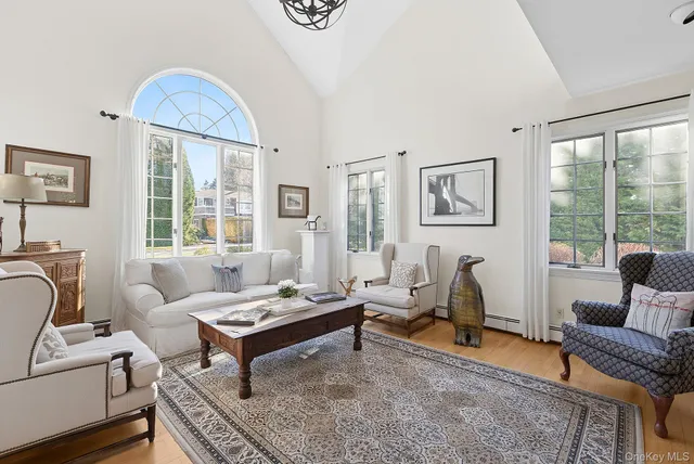 a living room with furniture a table and a large window