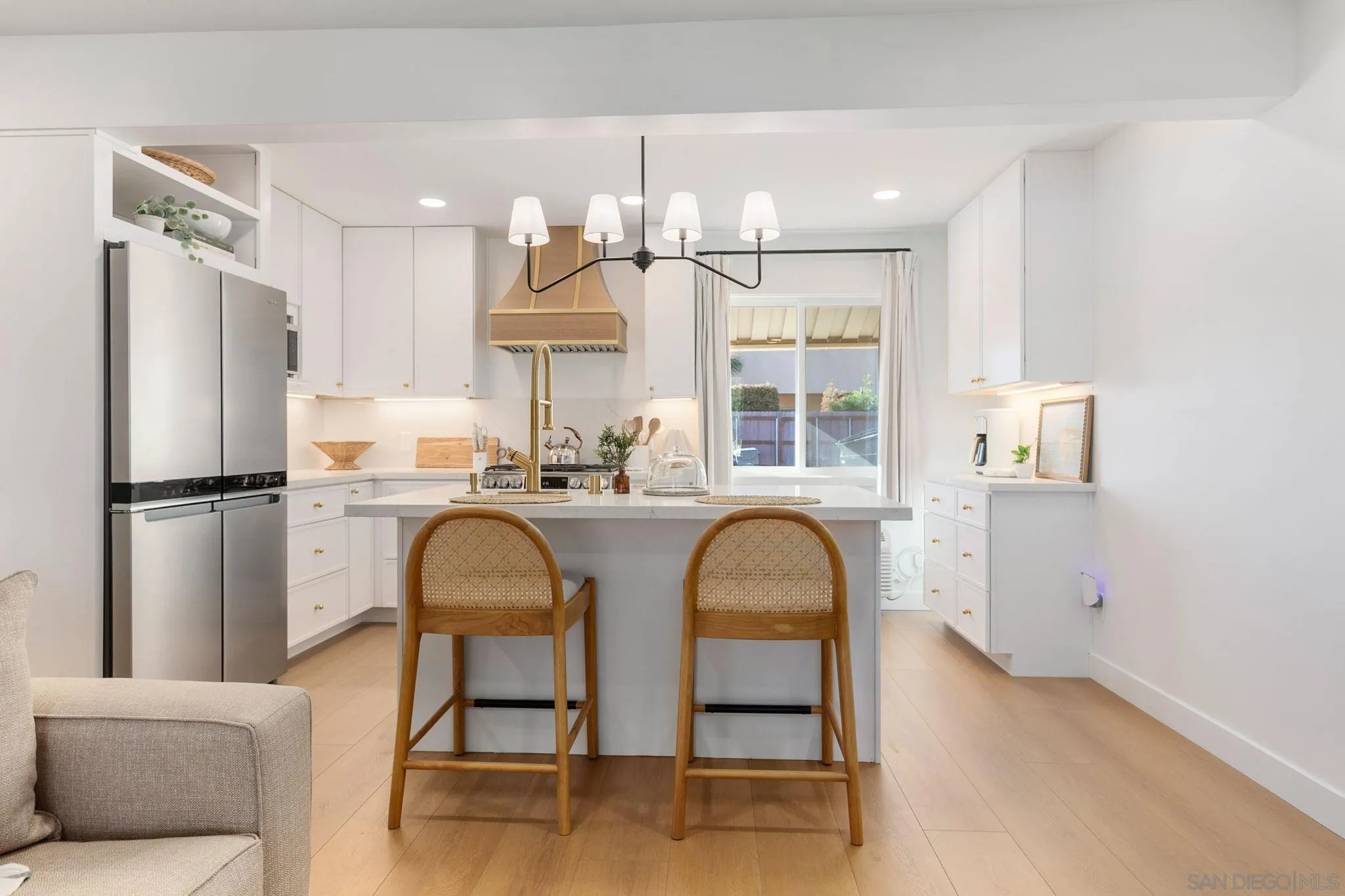 210 A Street, Unit 2 Encinitas, CA 92024 - Photo 9 of 44 a kitchen with stainless steel appliances granite countertop a refrigerator a sink dishwasher a dining table and chairs with wooden floor