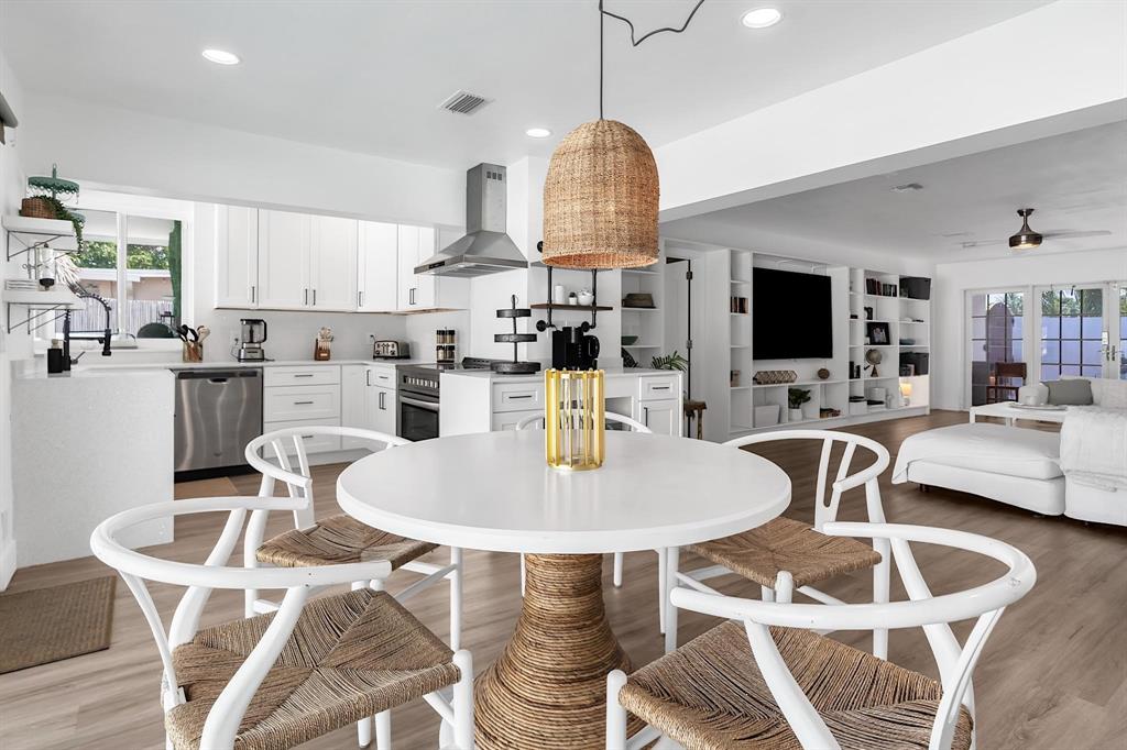 2233 Southeast 15th Street Pompano Beach, FL 33062 - Photo 27 of 53 a kitchen with stainless steel appliances kitchen island granite countertop a dining table chairs and a oven