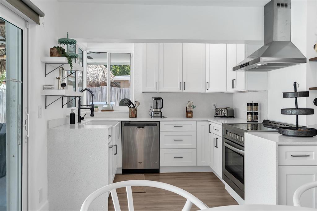 2233 Southeast 15th Street Pompano Beach, FL 33062 - Photo 28 of 53 a kitchen with white cabinets and white appliances