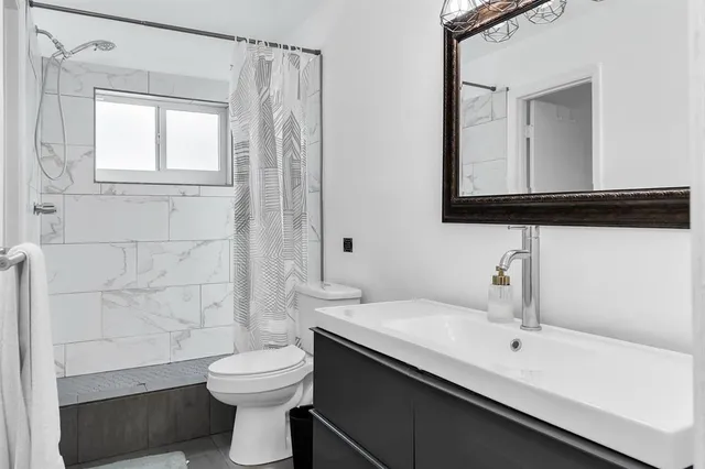 a bathroom with a toilet sink and mirror
