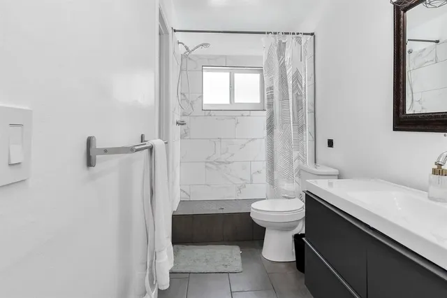 a front view of a house with a yard and potted plants
