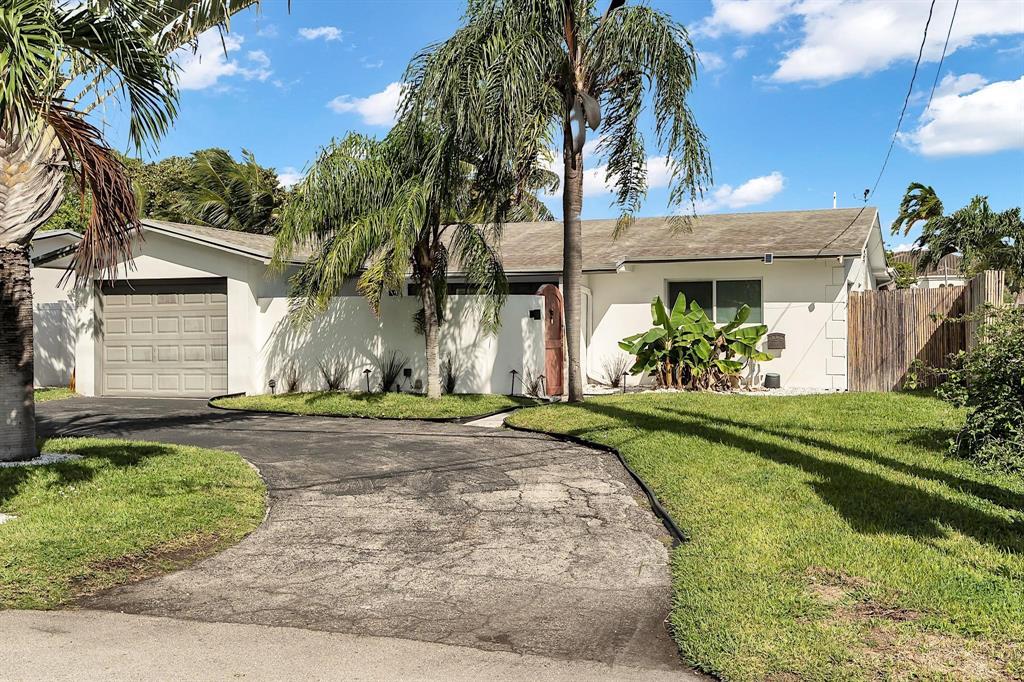 2233 Southeast 15th Street Pompano Beach, FL 33062 - Photo 50 of 53 a front view of a house with a yard and potted plants