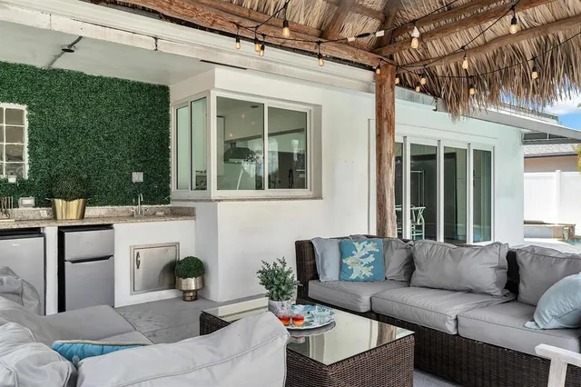 a view of a patio with couches table and chairs and potted plants