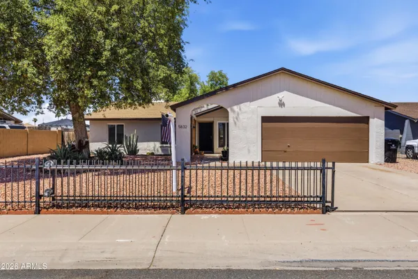 a view of a house with a wooden fence