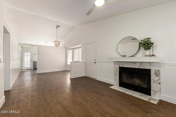 an empty room with wooden floor a fireplace and windows