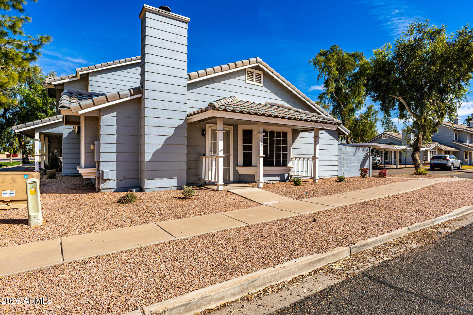 860 North McQueen Road, Unit 1092 Chandler, AZ 85225 - Photo 3 of 26 a view of a white house with large windows and palm tree