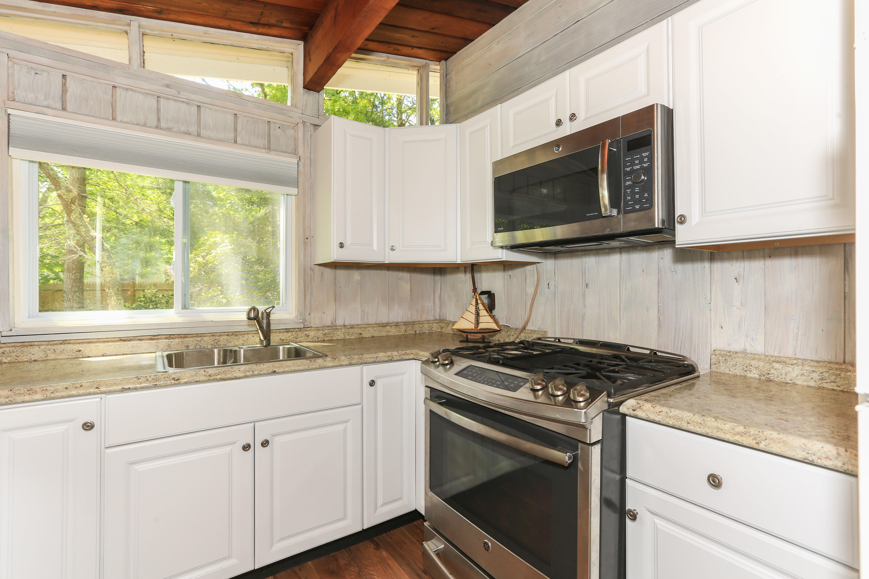 38 Lakeside Drive Marstons Mills, MA 02648 - Photo 5 of 21 a kitchen with stainless steel appliances granite countertop white cabinets granite counter tops and a wooden floors