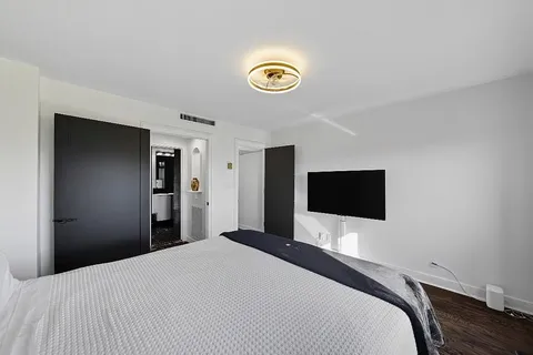 a bedroom with a bed and a flat screen tv