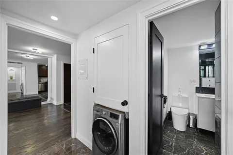 a view of a hallway with bathroom and wooden floor