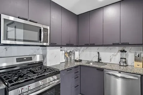 a kitchen with granite countertop stainless steel appliances and cabinets