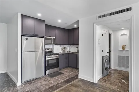 a kitchen with stainless steel appliances granite countertop a refrigerator and a stove top oven