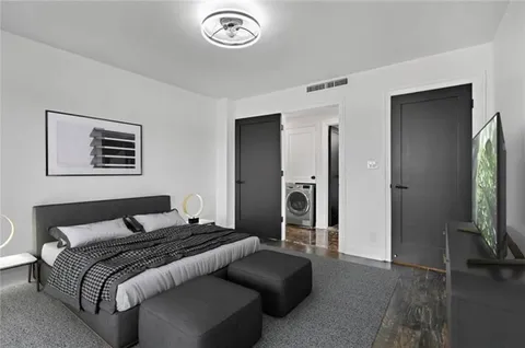 a bedroom with a bed and a flat tv screen