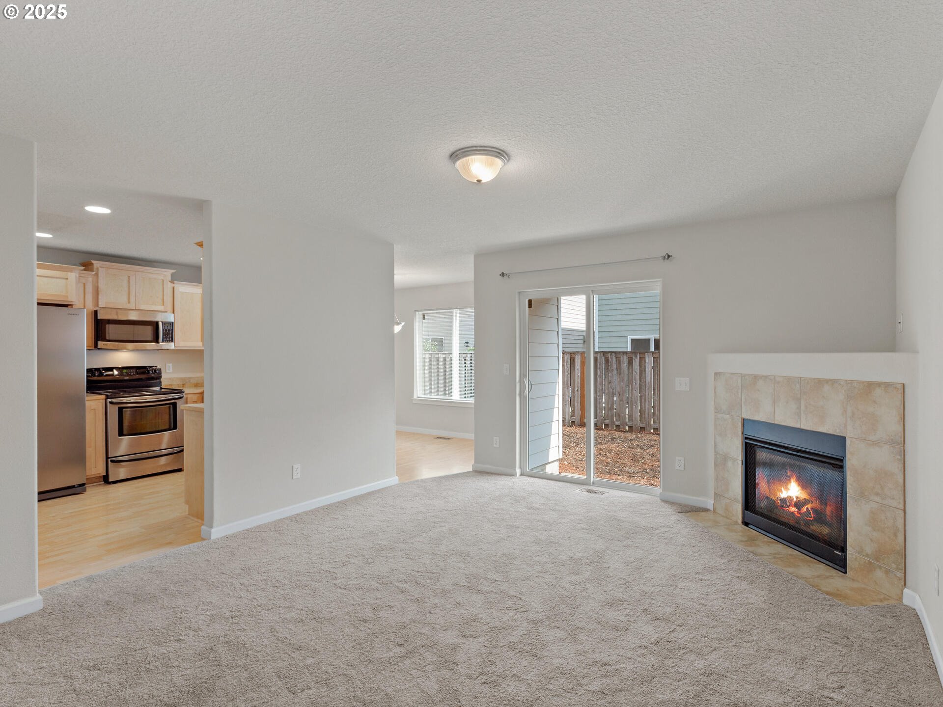 2709 Fletch Street Forest Grove, OR 97116 - Photo 10 of 44 a view of a kitchen and an empty room with a fireplace