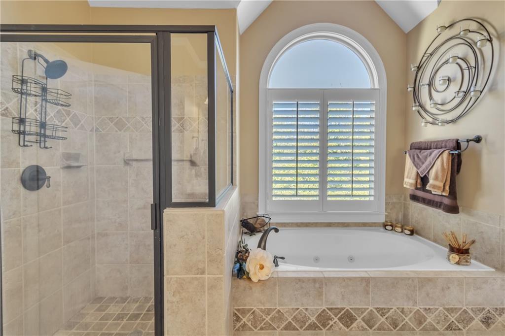 1611 Silvergrass Lane Grayson, GA 30017 - Photo 39 of 90 a bathroom with a tub a window and a shower
