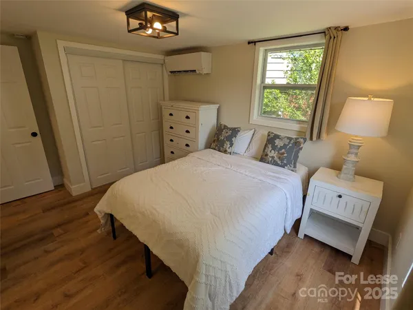 a bedroom with a bed and a lamp on dresser