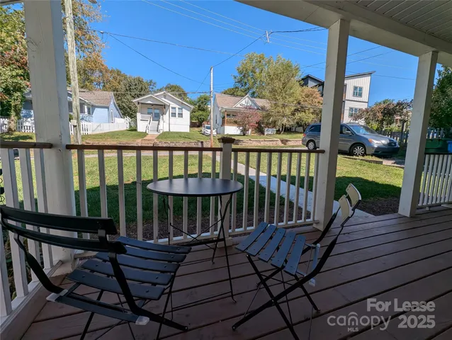 a view of a balcony with chairs and wooden floor