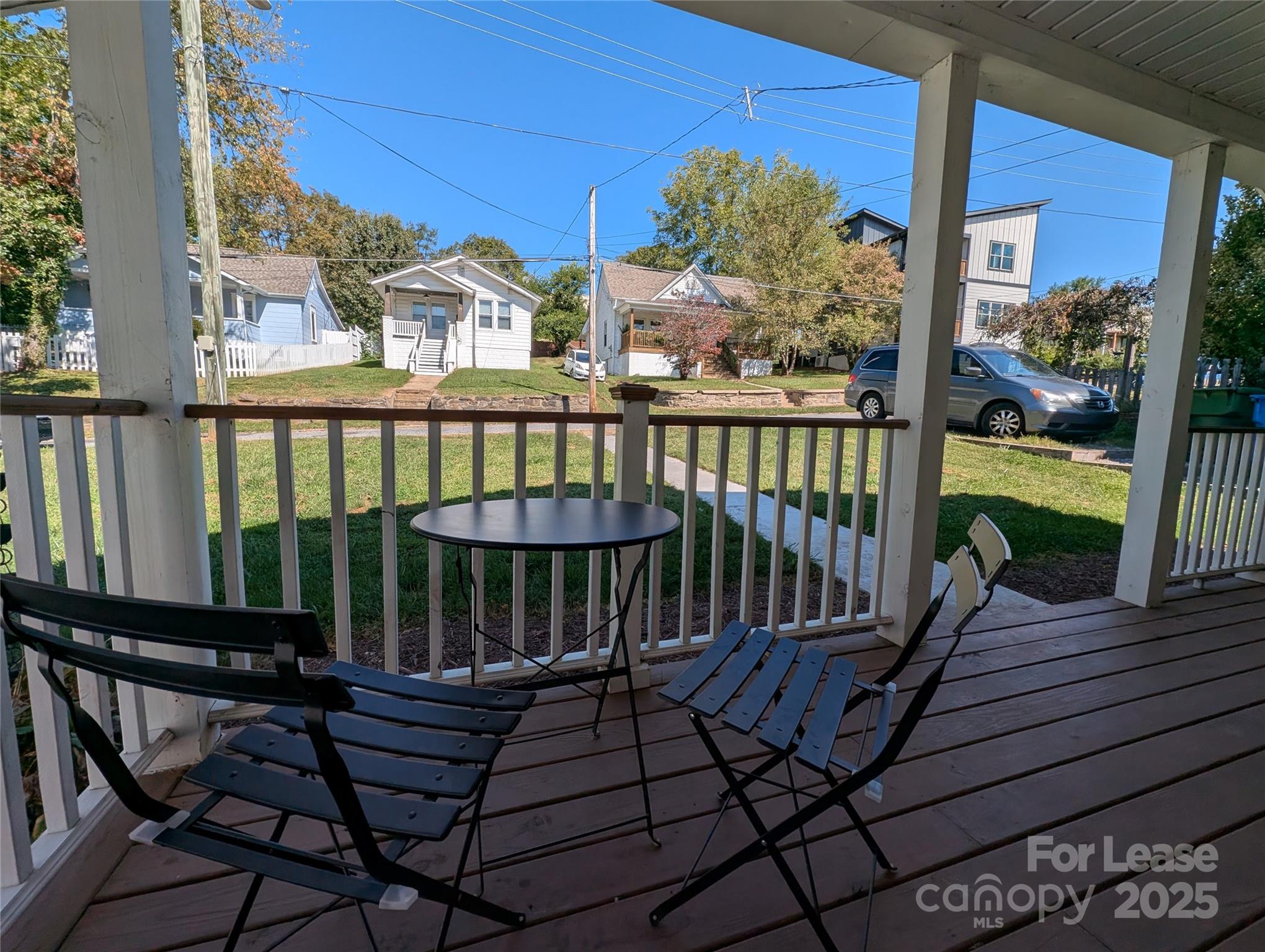 29 Woodrow Avenue, Unit 1 Asheville, NC 28801 - Photo 21 of 23 a view of a balcony with chairs and wooden floor