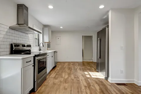 a kitchen with stainless steel appliances granite countertop a stove a sink and a refrigerator