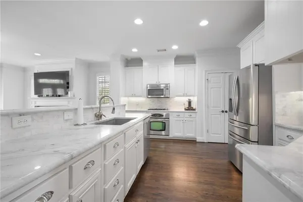 a kitchen with stainless steel appliances granite countertop a sink stove and refrigerator