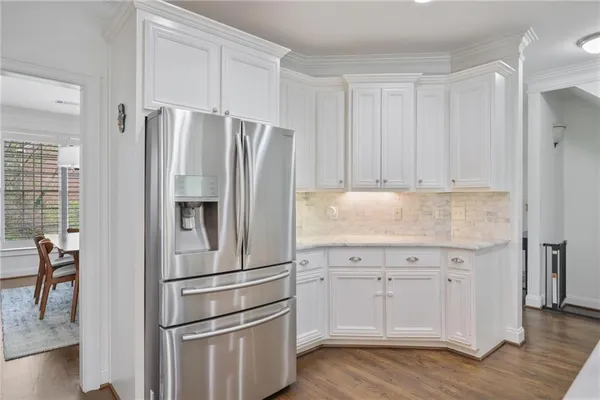 a kitchen with cabinets stainless steel appliances and a wooden floor