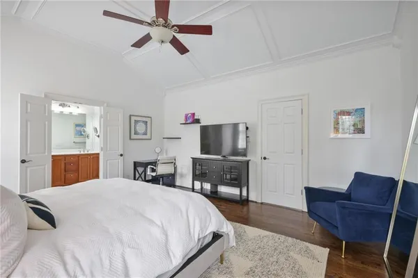 a bedroom with a bed a chair a computer on the desk and chair