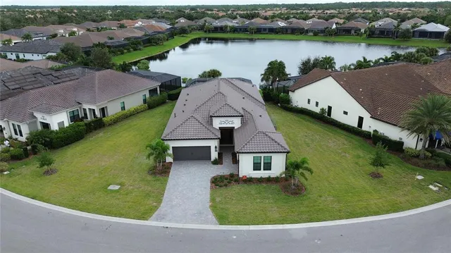 an aerial view of a house with garden space and lake view