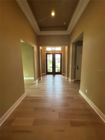 a view of a hallway with wooden floor and windows