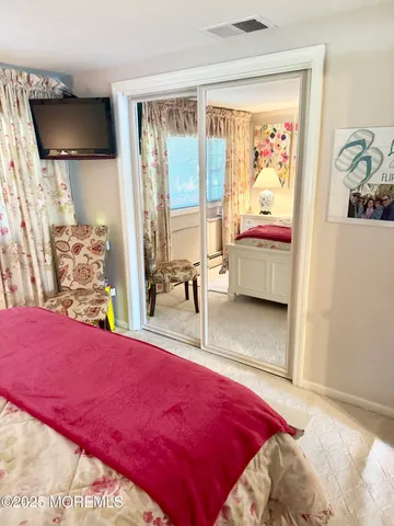 a bedroom with a bed and flat screen tv