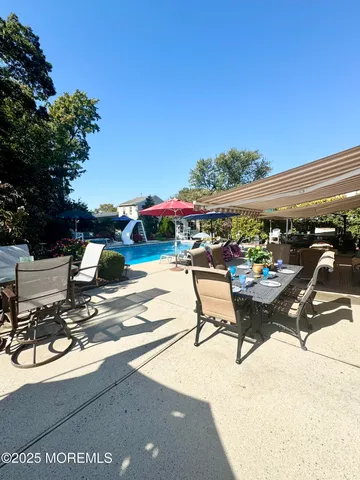 a patio with a table and chairs under an umbrella