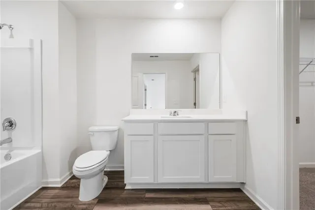 a bathroom with a sink a toilet and a large mirror
