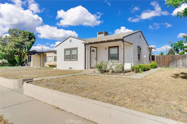 a view of a white house next to a yard