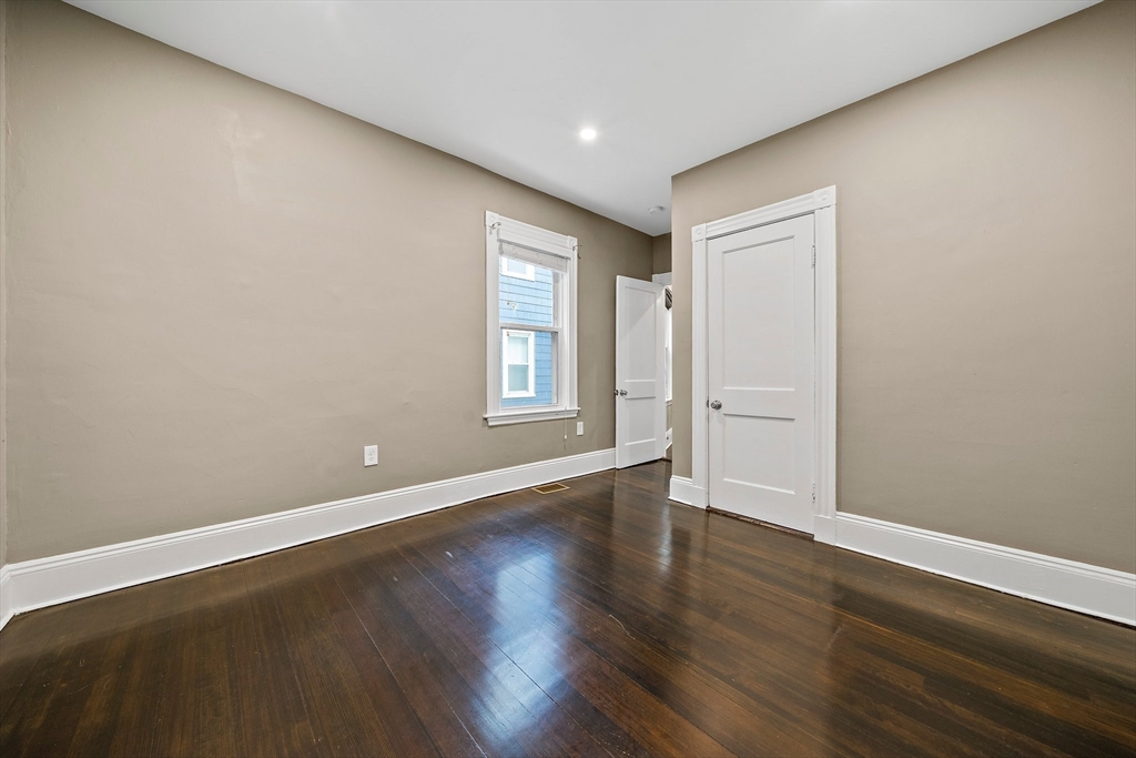 123 King Street, Unit 1 Boston, MA 02122 - Photo 17 of 24 a view of an empty room with wooden floor and windows