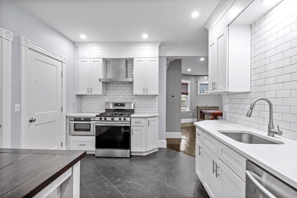 123 King Street, Unit 1 Boston, MA 02122 - Photo 3 of 24 a kitchen with stainless steel appliances granite countertop a sink stove and refrigerator