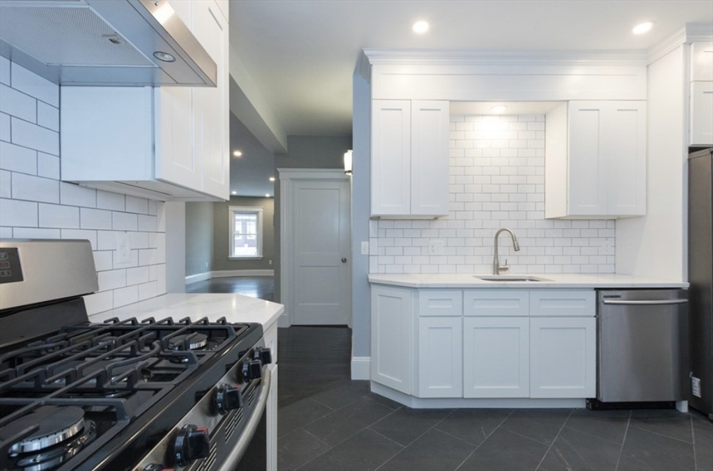 123 King Street, Unit 1 Boston, MA 02122 - Photo 5 of 24 a kitchen with a stove and white cabinets