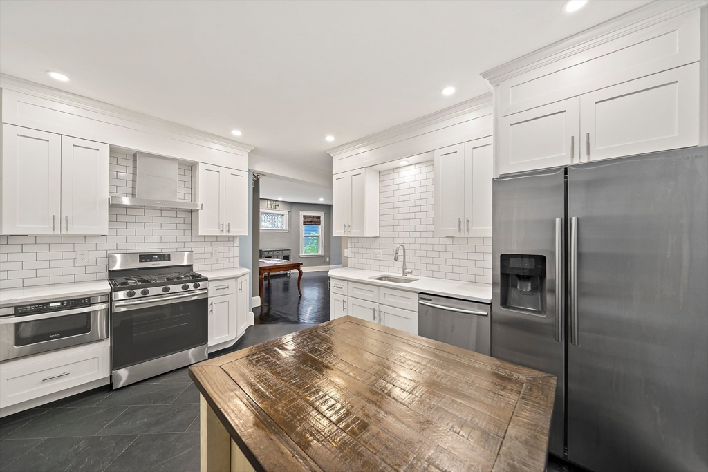 123 King Street, Unit 1 Boston, MA 02122 - Photo 6 of 24 a kitchen with granite countertop stainless steel appliances and wooden cabinets