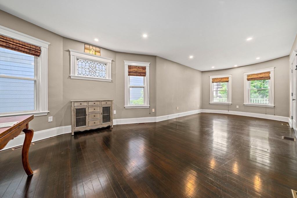 123 King Street, Unit 1 Boston, MA 02122 - Photo 8 of 24 a view of an empty room with wooden floor and a window