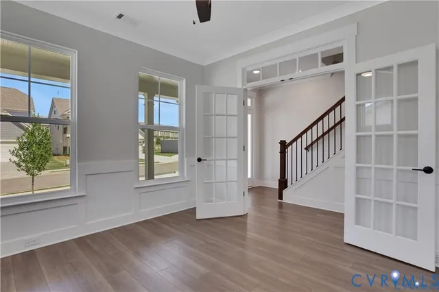 an empty room with wooden floor and windows