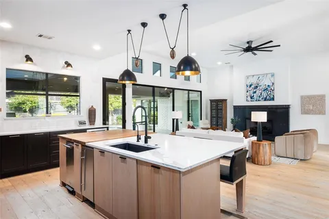 a kitchen with a stove a sink a kitchen island with a dining table and chairs