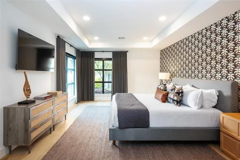 a bedroom with a bed and a flat screen tv