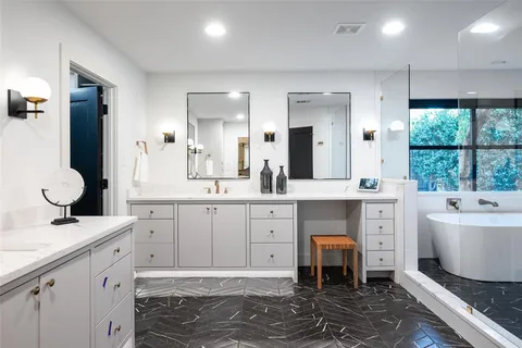 a spacious bathroom with a double vanity sink a mirror and a bathtub